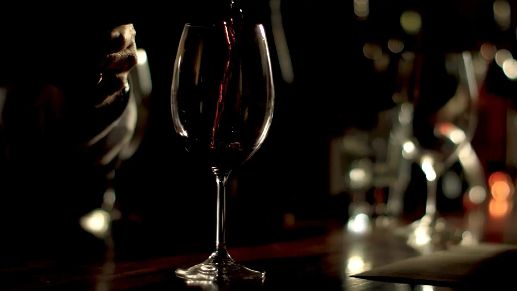 a person pouring wine into a glass